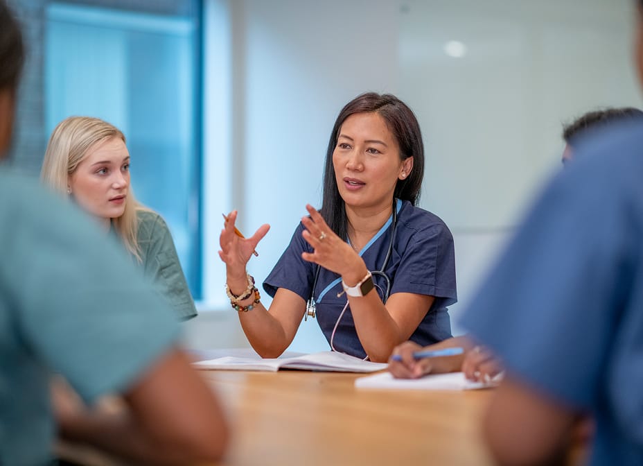 Nurse speaking during a meeting with healthcare colleagues