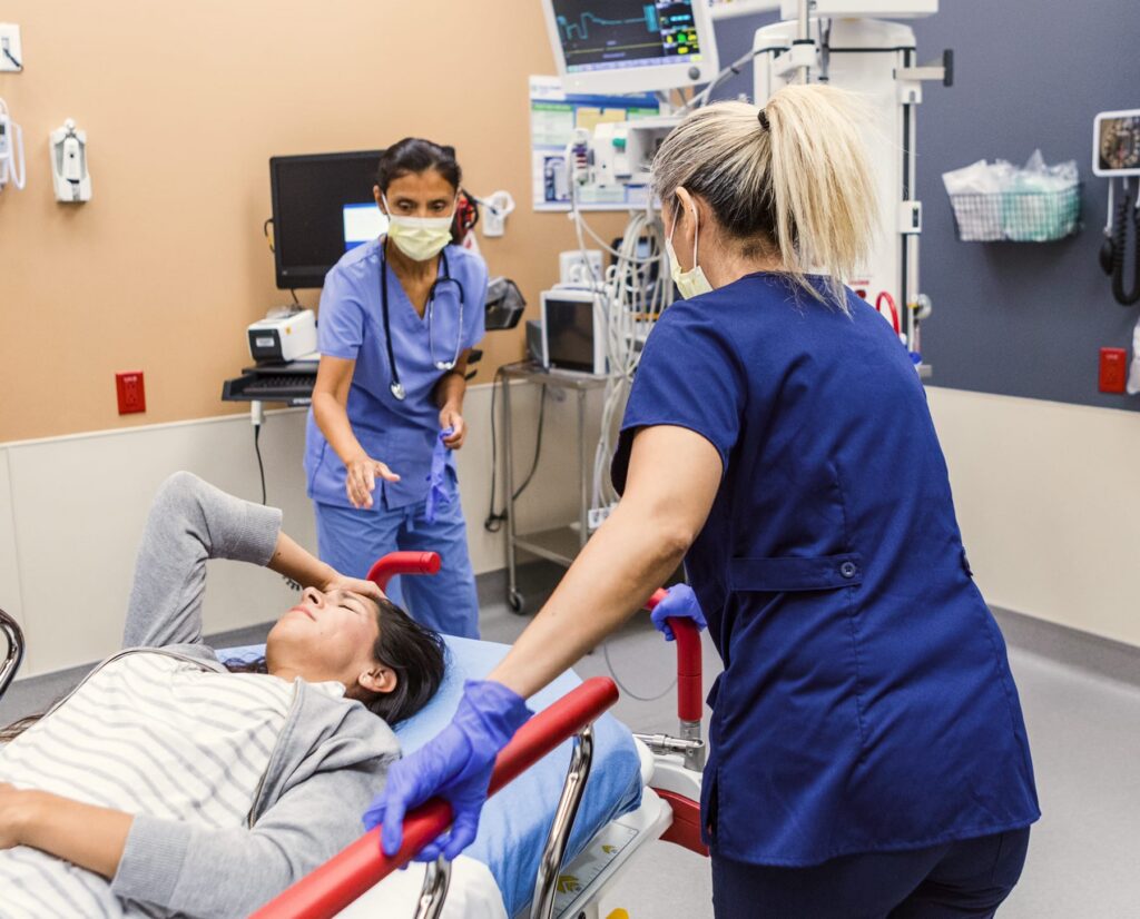 Nurses providing emergency care to a patient in a hospital treatment room