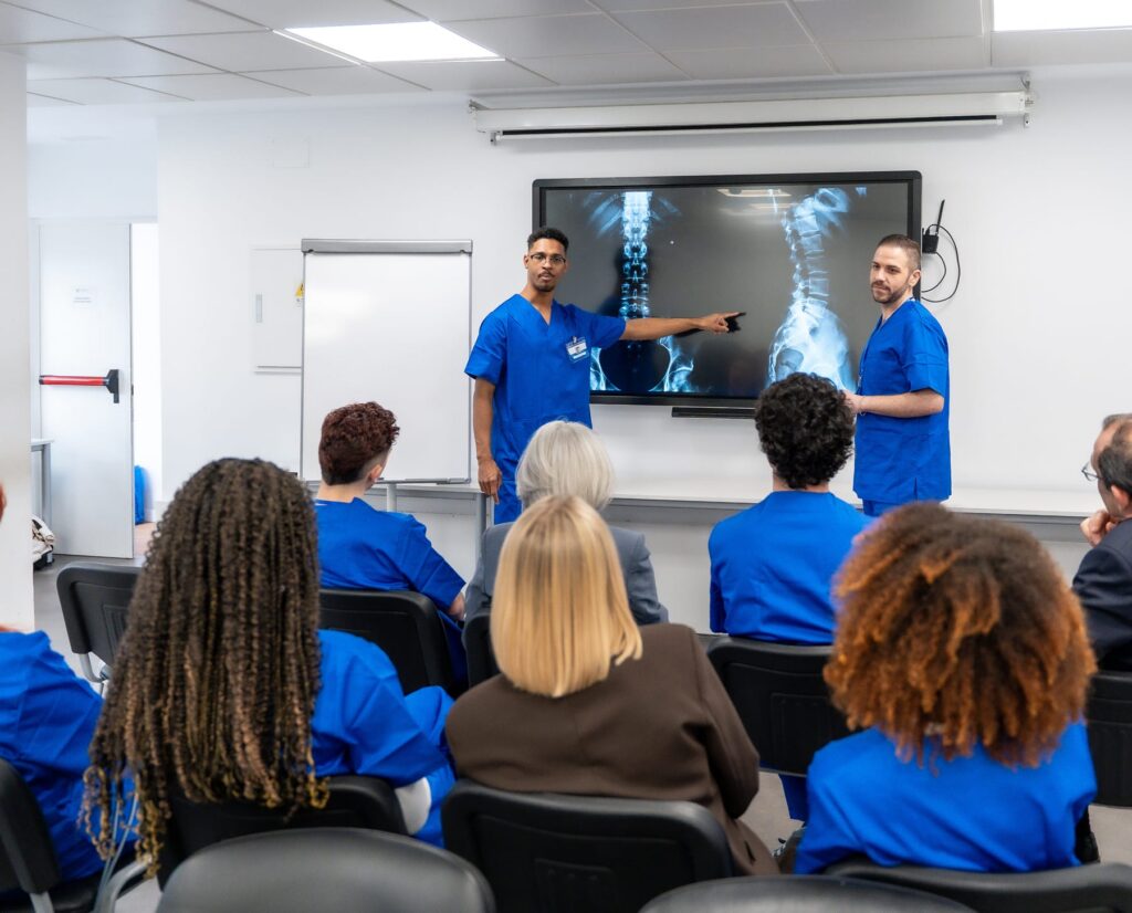 Nurses giving a presentation to colleagues in a hospital conference room