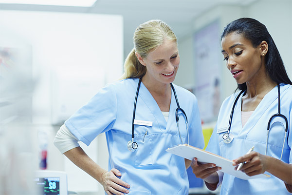 Two Nurses discussing Magnet Response results from a clipboard